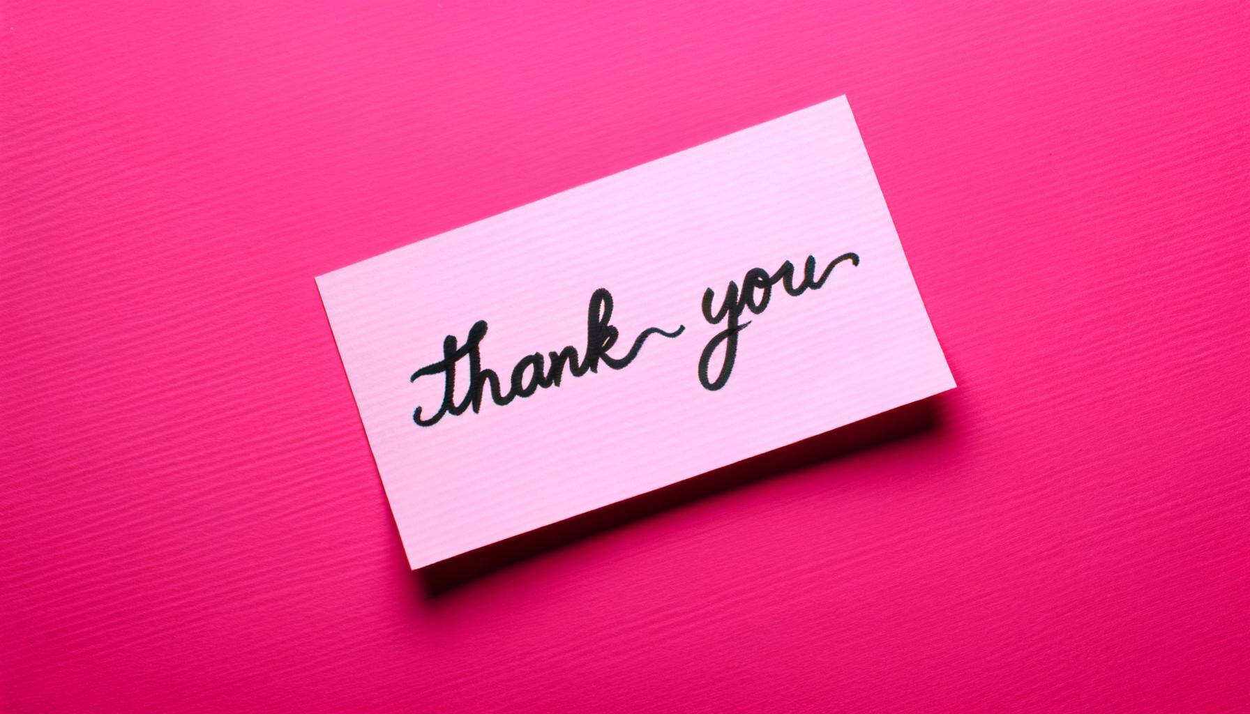 a handwritten thank you note on a pink background-1